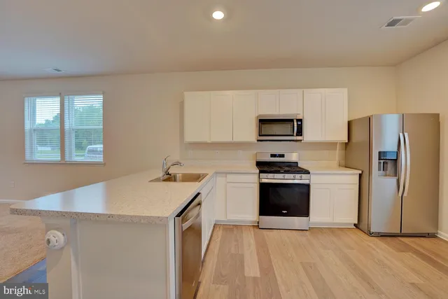 a kitchen with a stove a refrigerator and a sink