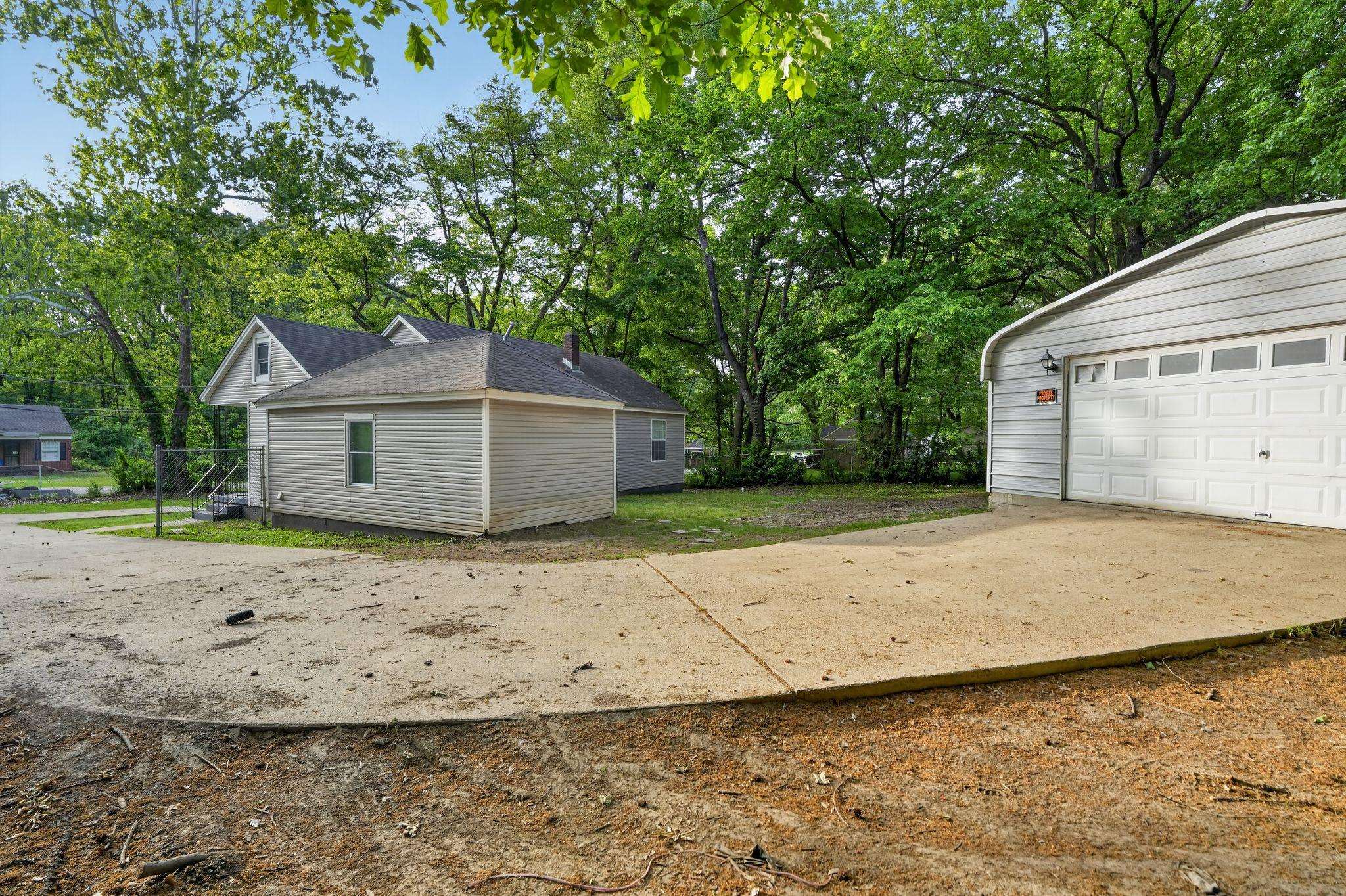 4199 Auburn Road Memphis, TN 38116 - Photo 31 of 32 Detached garage with horizontal siding, a multi-pane overhead door, and exterior lighting