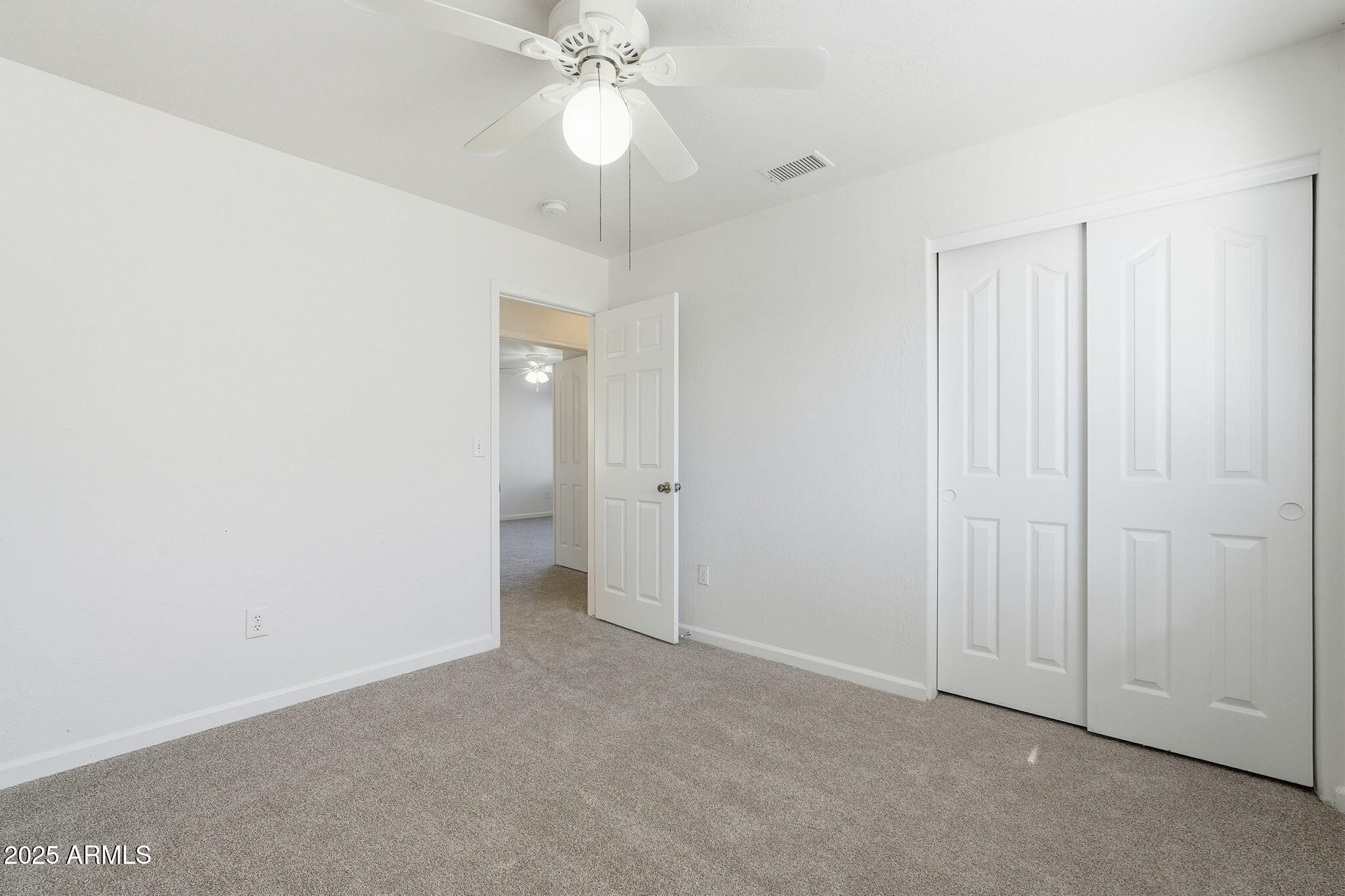 2061 East Appaloosa Road Gilbert, AZ 85296 - Photo 19 of 37 an empty room with a chandelier fan and closet area
