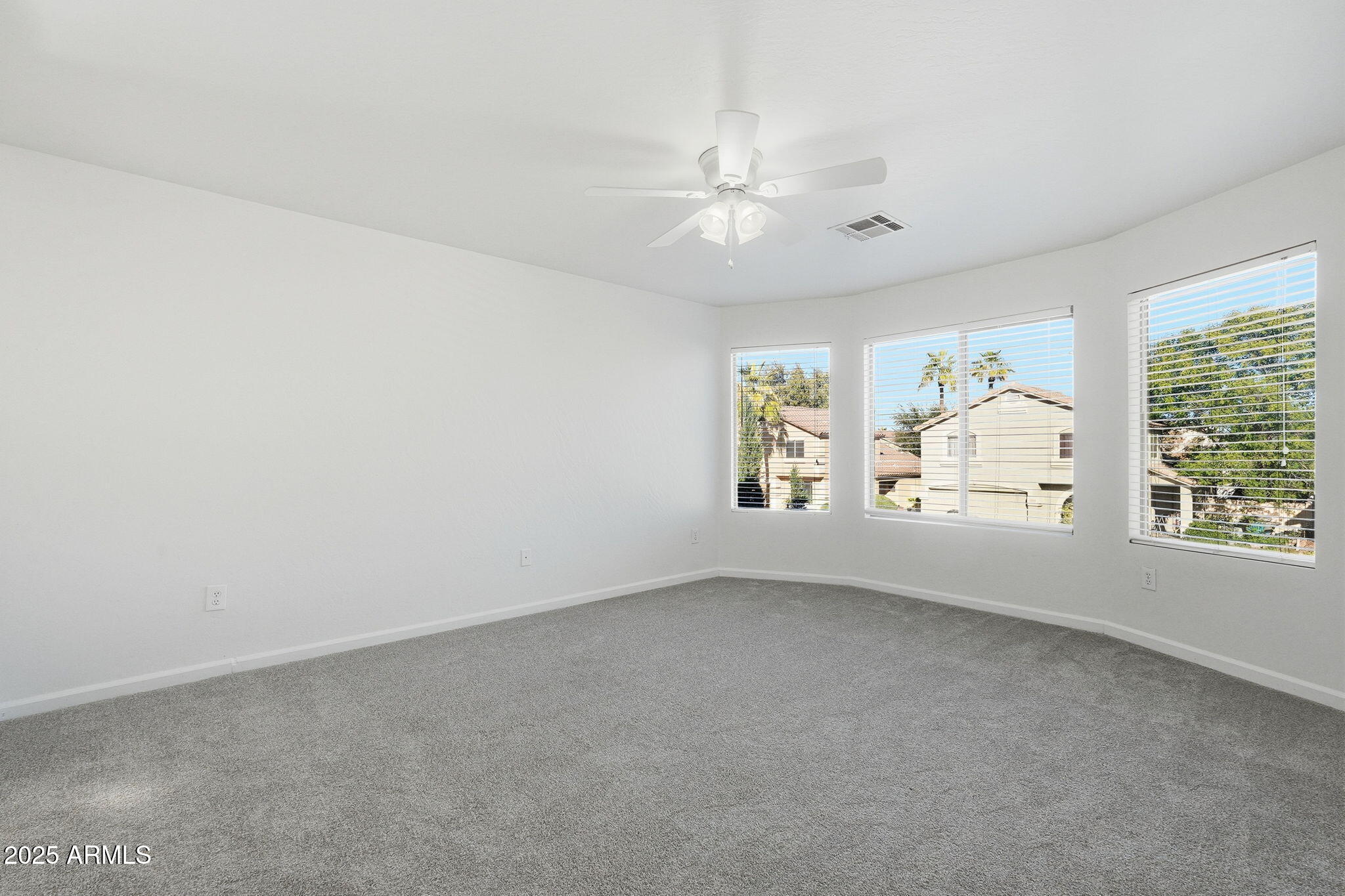 2061 East Appaloosa Road Gilbert, AZ 85296 - Photo 8 of 37 an empty room with windows and chandelier fan
