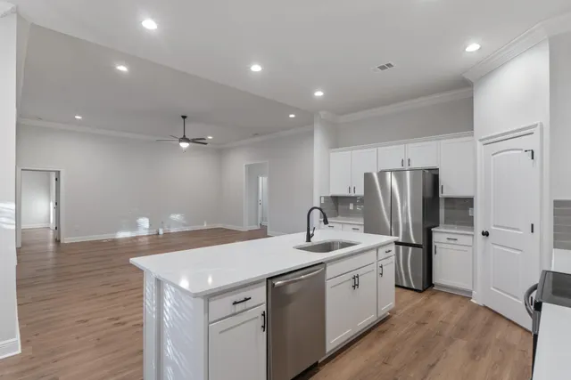 a kitchen with white cabinets and stainless steel appliances