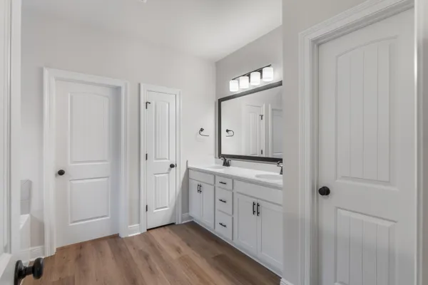 a bathroom with double vanity sinks and a mirror
