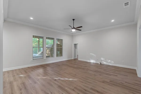 a view of an empty room with wooden floor
