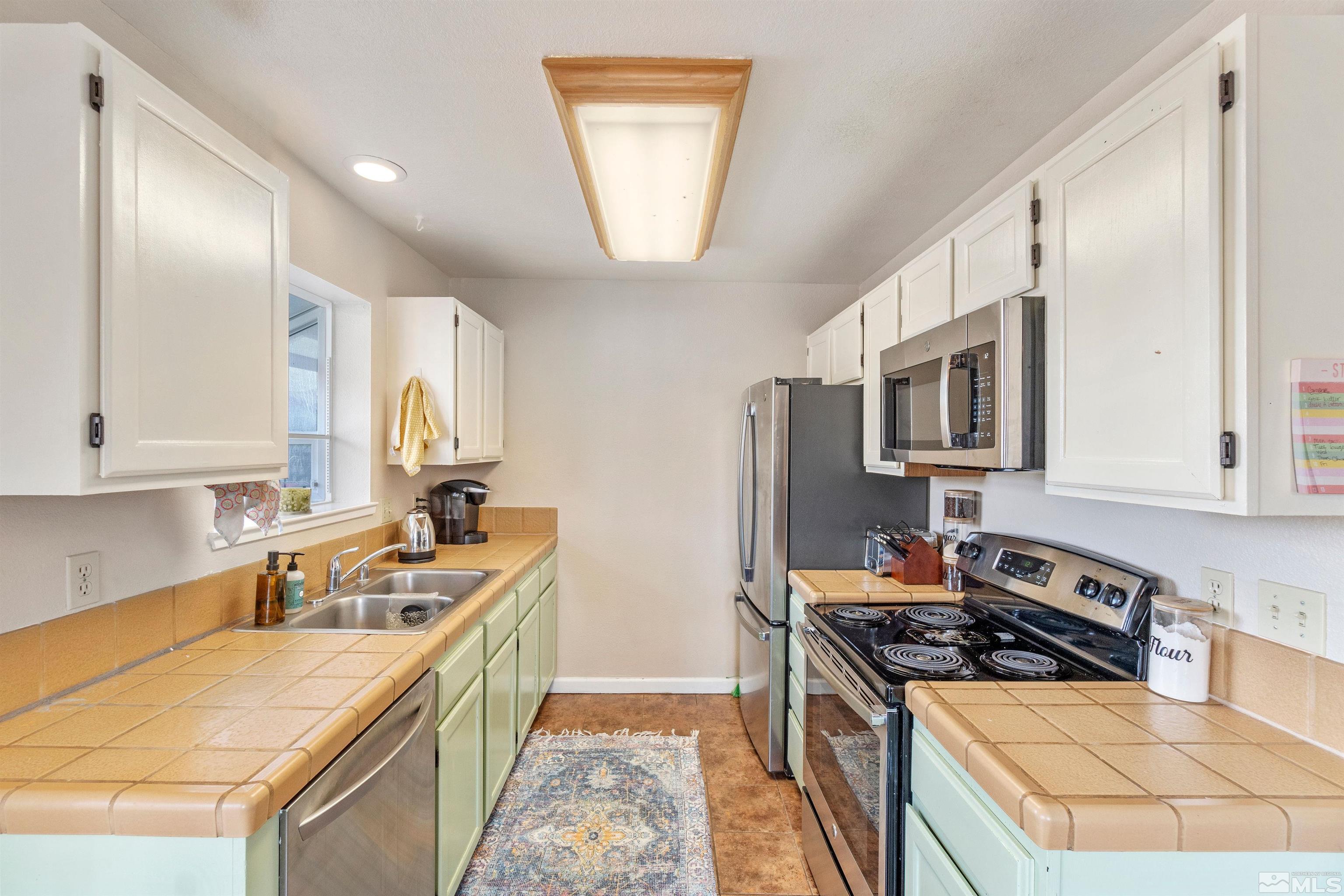 3971 Kings Row Reno, NV 89503 - Photo 18 of 29 a kitchen with stainless steel appliances a stove a sink a refrigerator white cabinets and a refrigerator