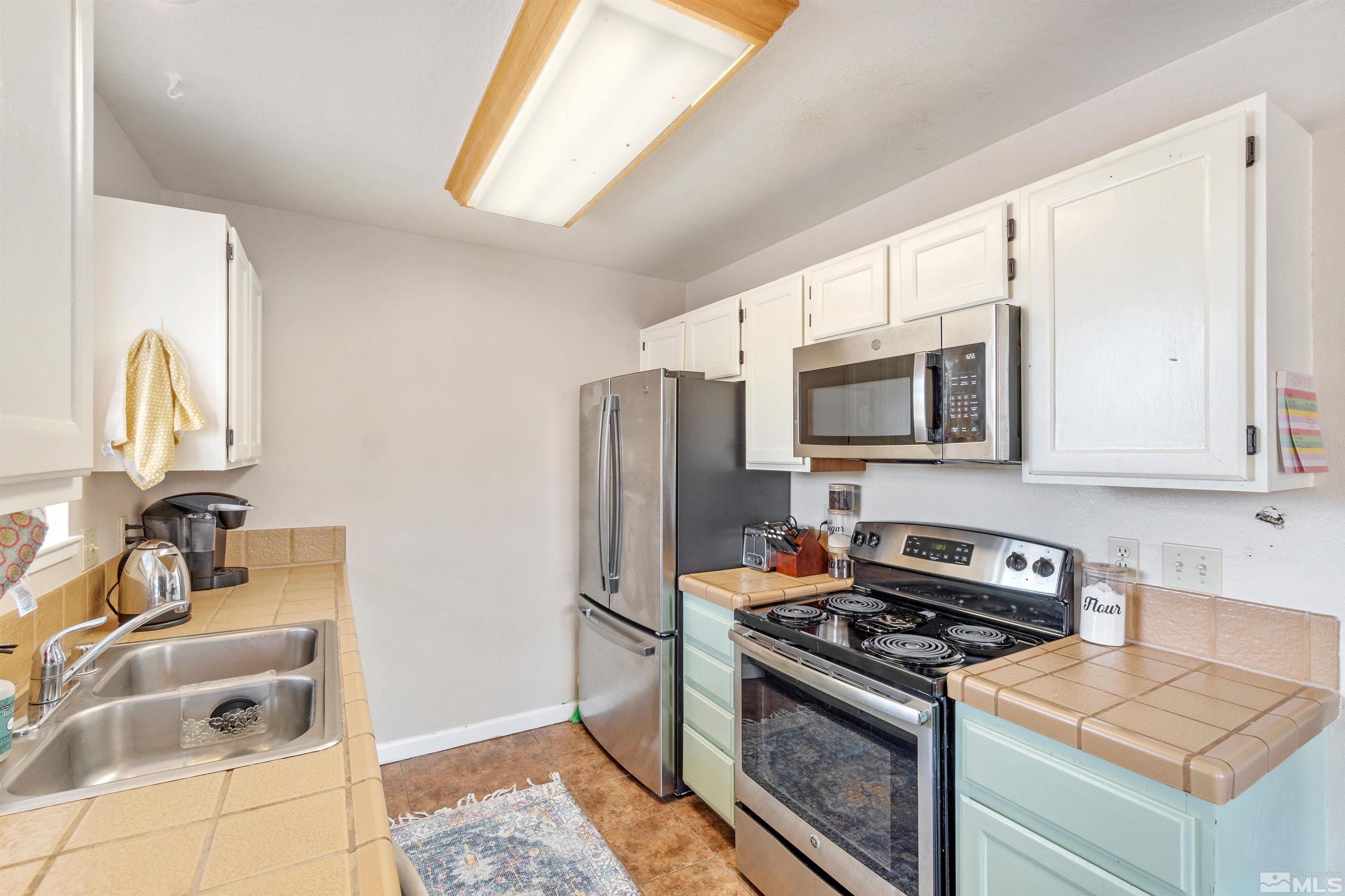 3971 Kings Row Reno, NV 89503 - Photo 19 of 29 a kitchen with stainless steel appliances granite countertop a sink stove and refrigerator