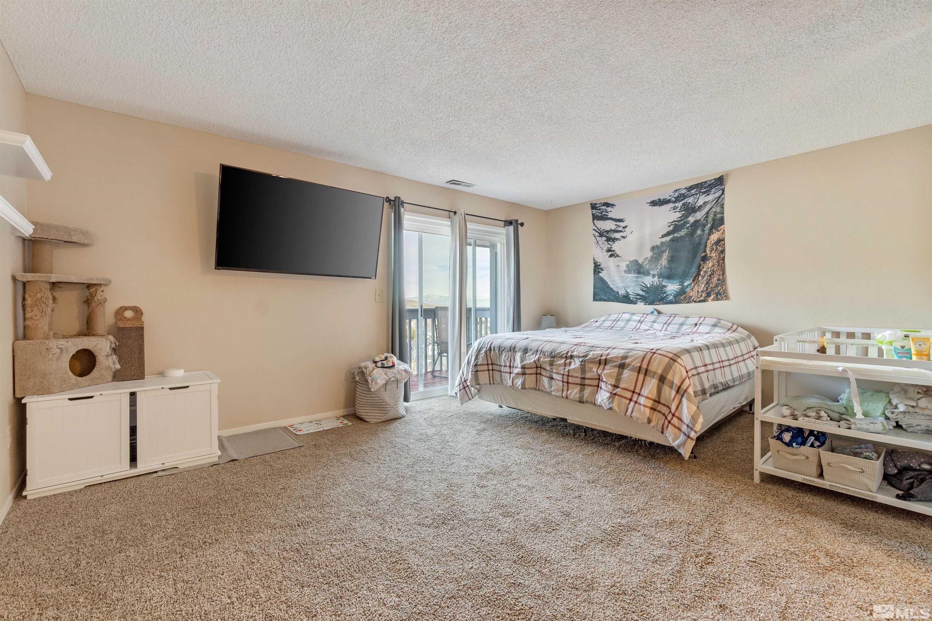 3971 Kings Row Reno, NV 89503 - Photo 25 of 29 a bedroom with a bed and a flat screen tv