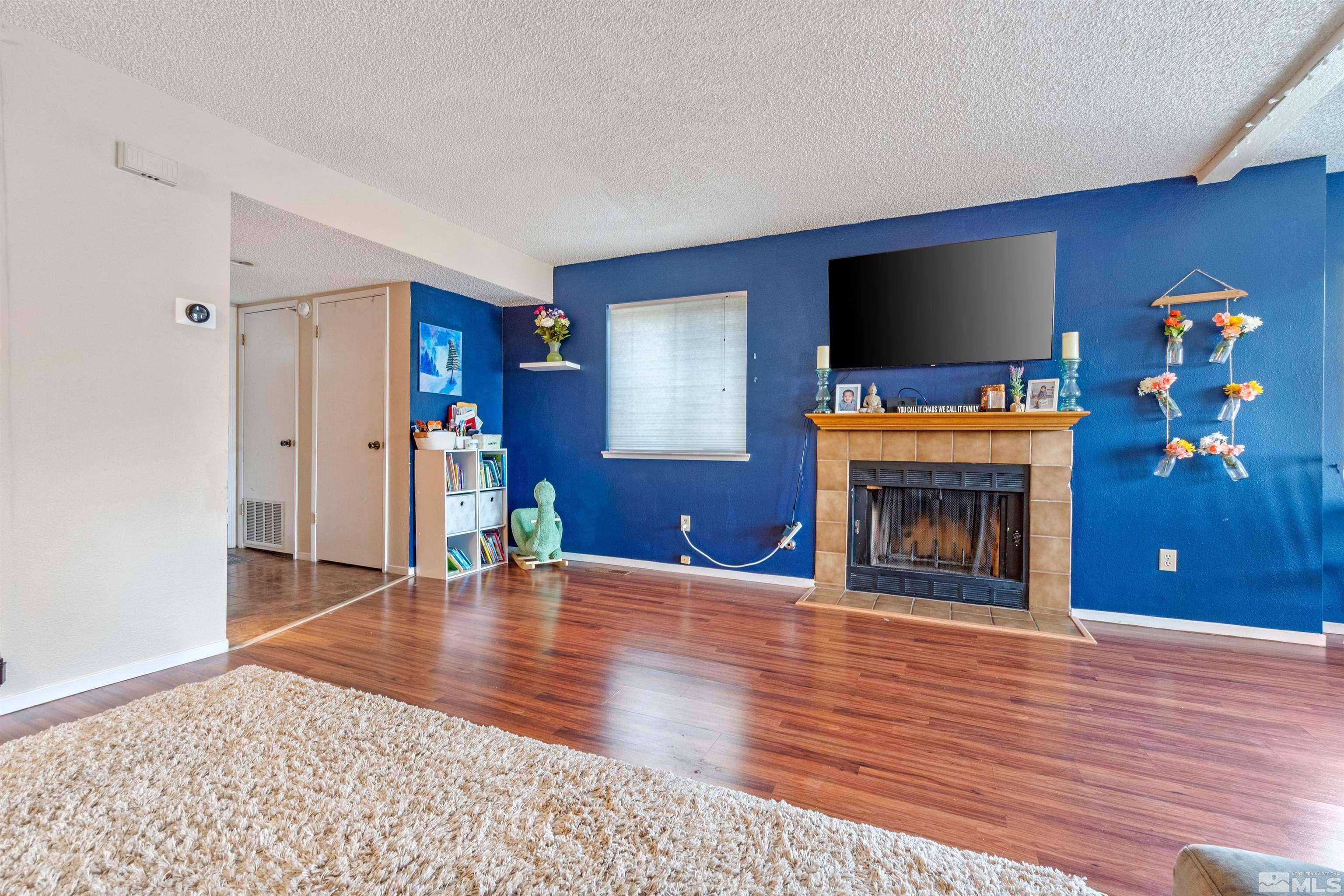 3971 Kings Row Reno, NV 89503 - Photo 10 of 29 a view of an empty room with a fireplace wooden floor and window