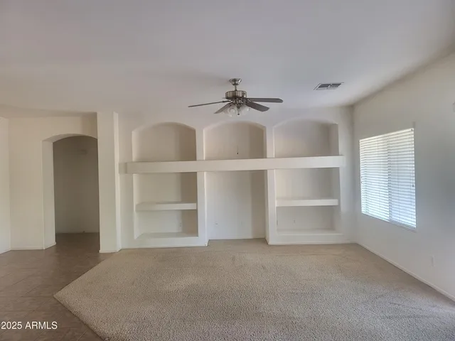 a view of a room with a cabinet and a ceiling fan