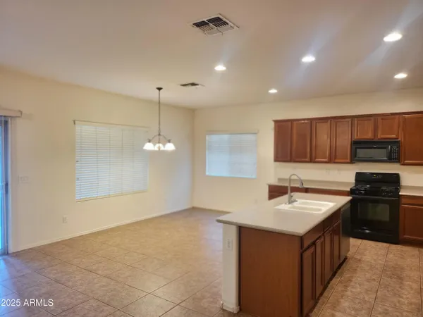 a kitchen with kitchen island granite countertop a sink stove and refrigerator