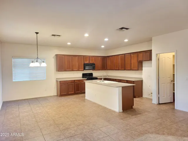 a large kitchen with a large counter top appliances and cabinets