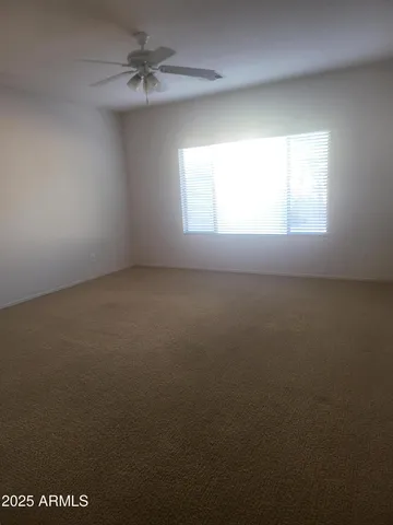 an empty room with a window and a ceiling fan