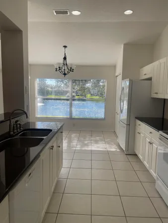 a kitchen with granite countertop white cabinets and white appliances