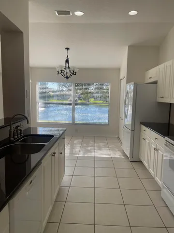a kitchen with granite countertop white cabinets and white appliances