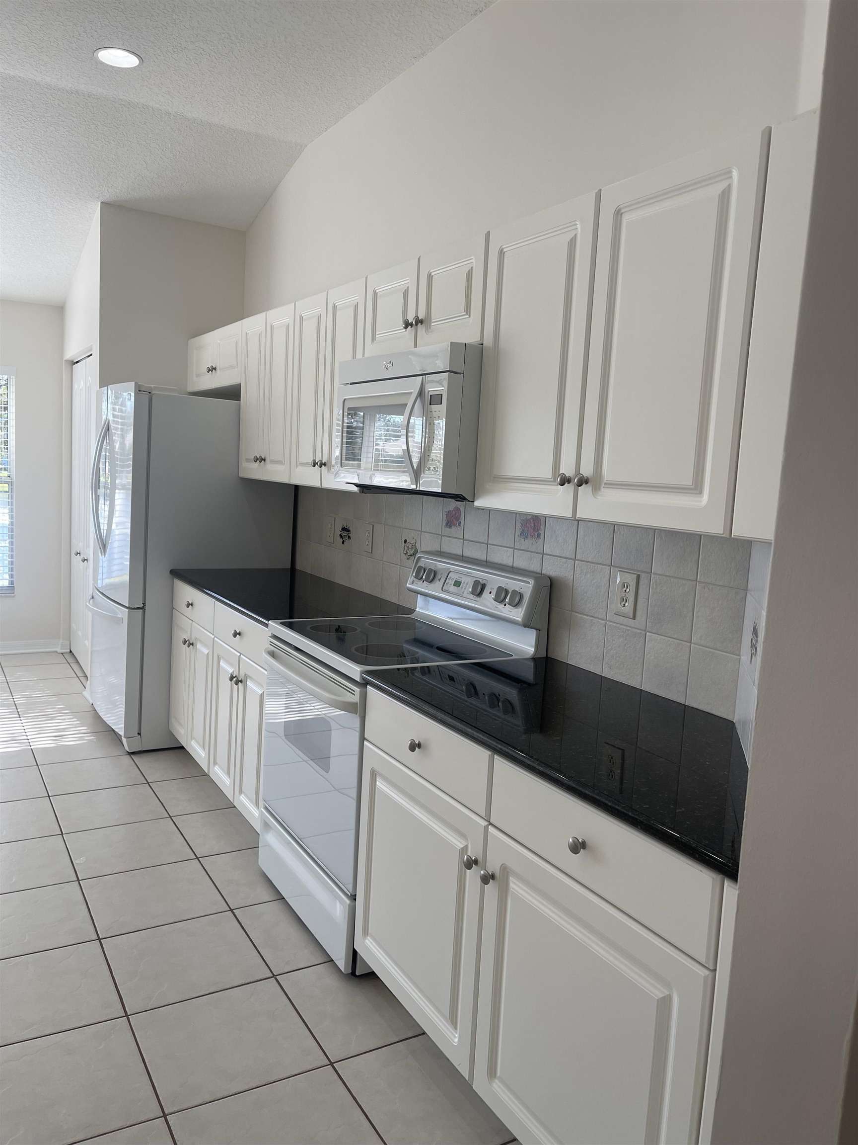1113 Compass Row St. Augustine, FL 32080 - Photo 10 of 29 a kitchen with granite countertop white cabinets and white appliances