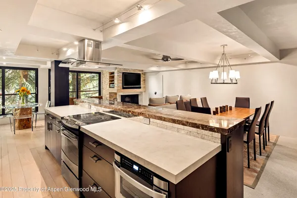 a kitchen with a stove a refrigerator and chairs