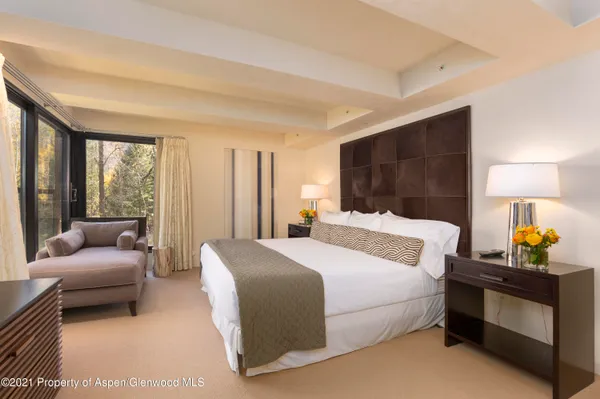 a bedroom with furniture and next to a window