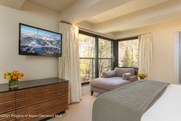 a bedroom with furniture and a large window