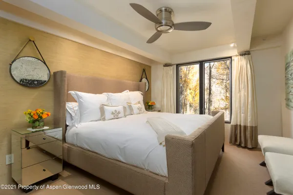 a bed room with large bed and windows