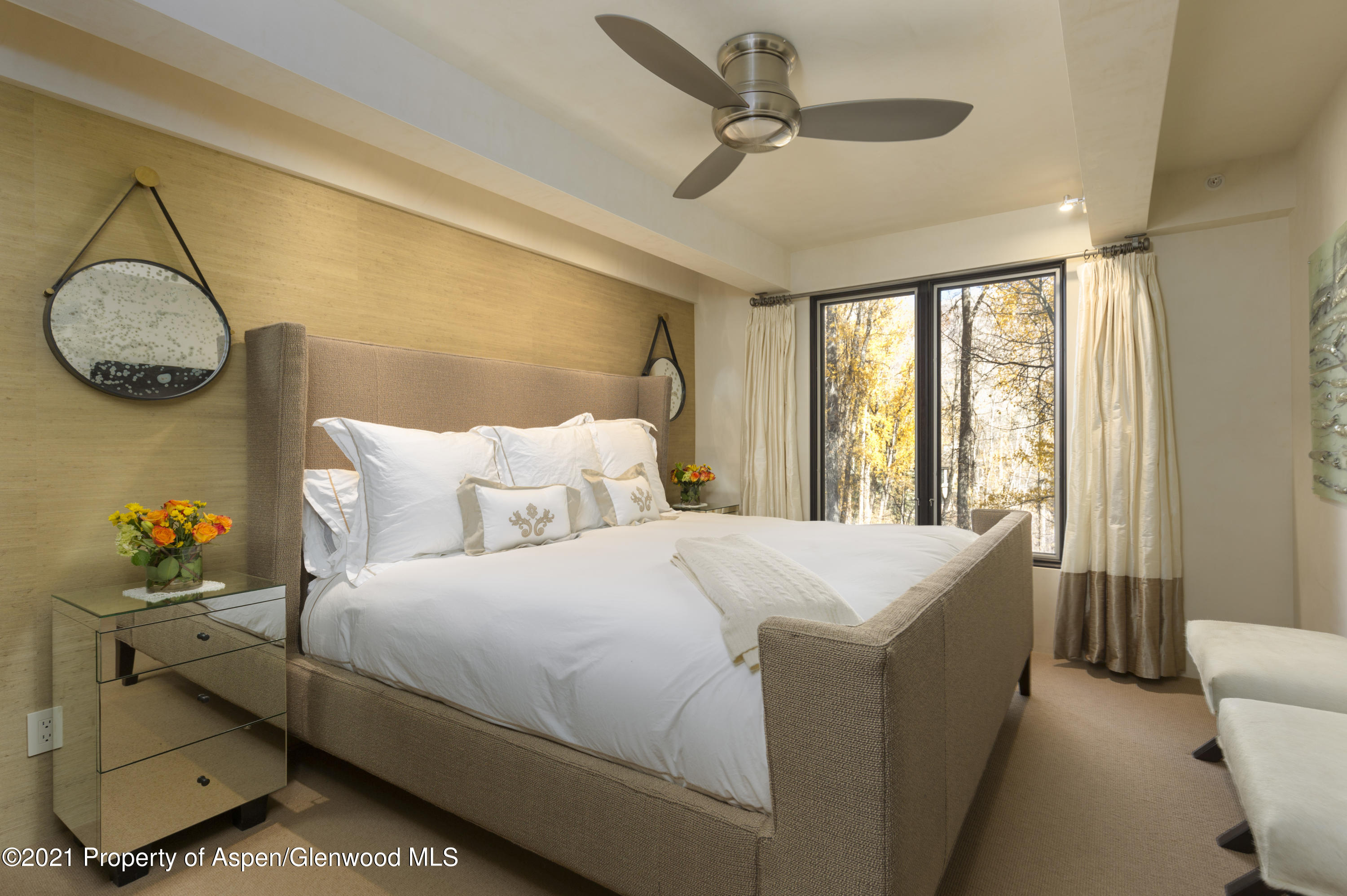 1034 East Cooper Avenue, Unit 26 Aspen, CO 81611 - Photo 19 of 23 a bedroom with a bed and a chandelier