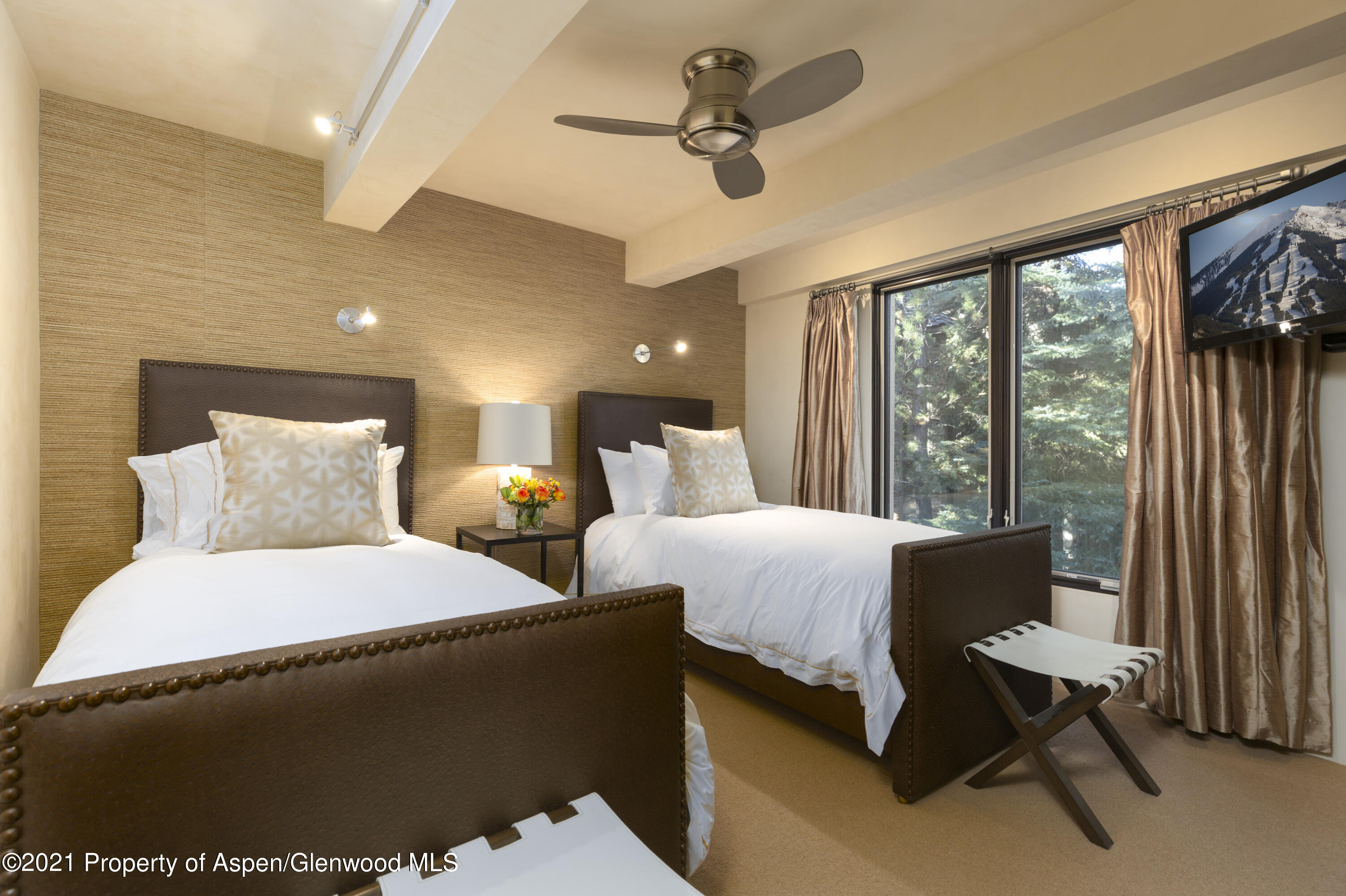 1034 East Cooper Avenue, Unit 26 Aspen, CO 81611 - Photo 20 of 23 a bed room with large bed and windows