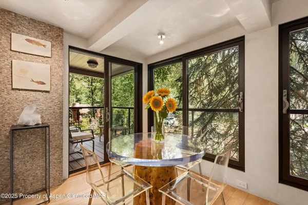 a view of a dining room with furniture and large windows
