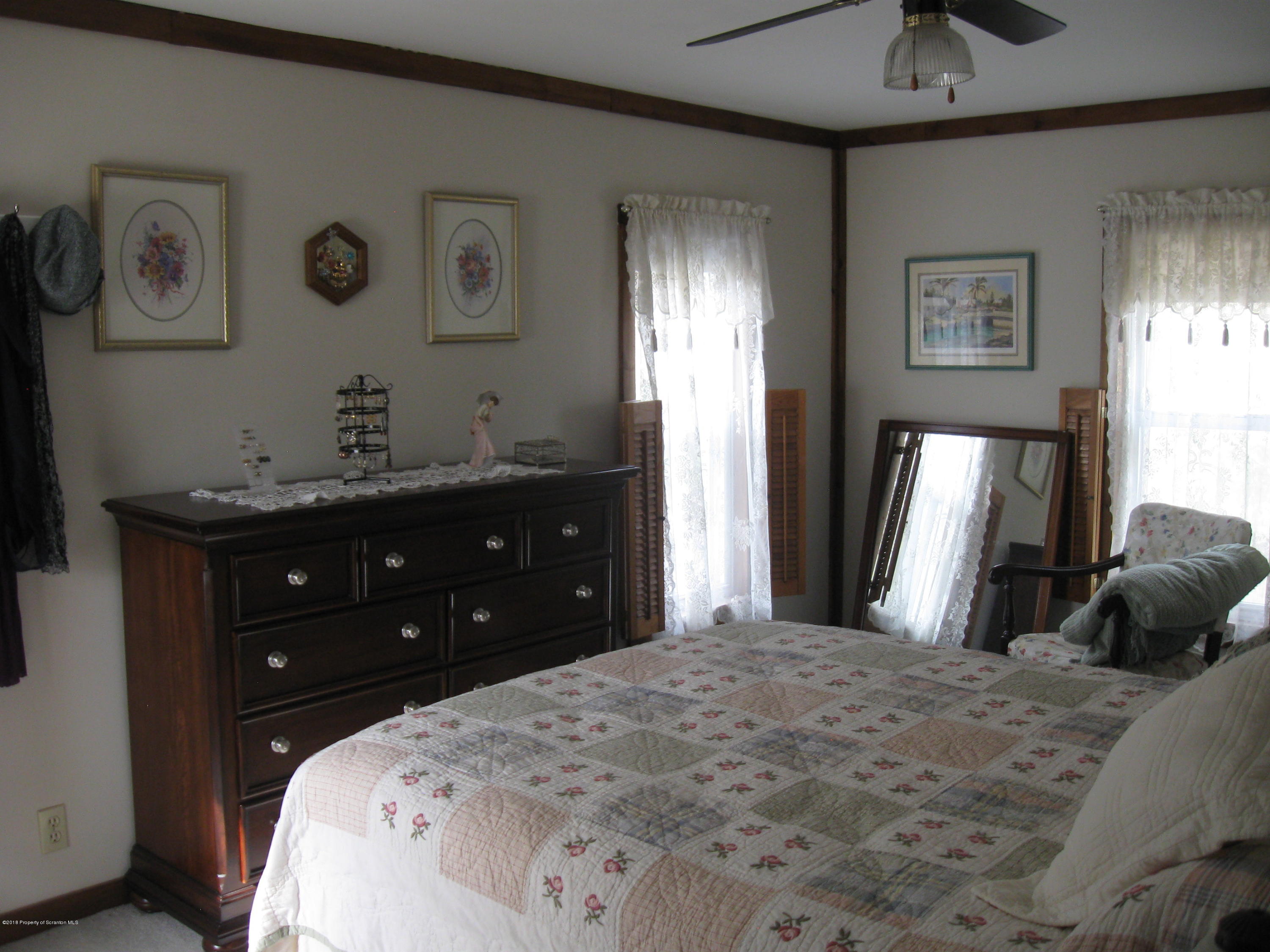 2744 State Rte 3013 Springville, PA 18844 - Photo 23 of 46 a bedroom with a bed and a chandelier