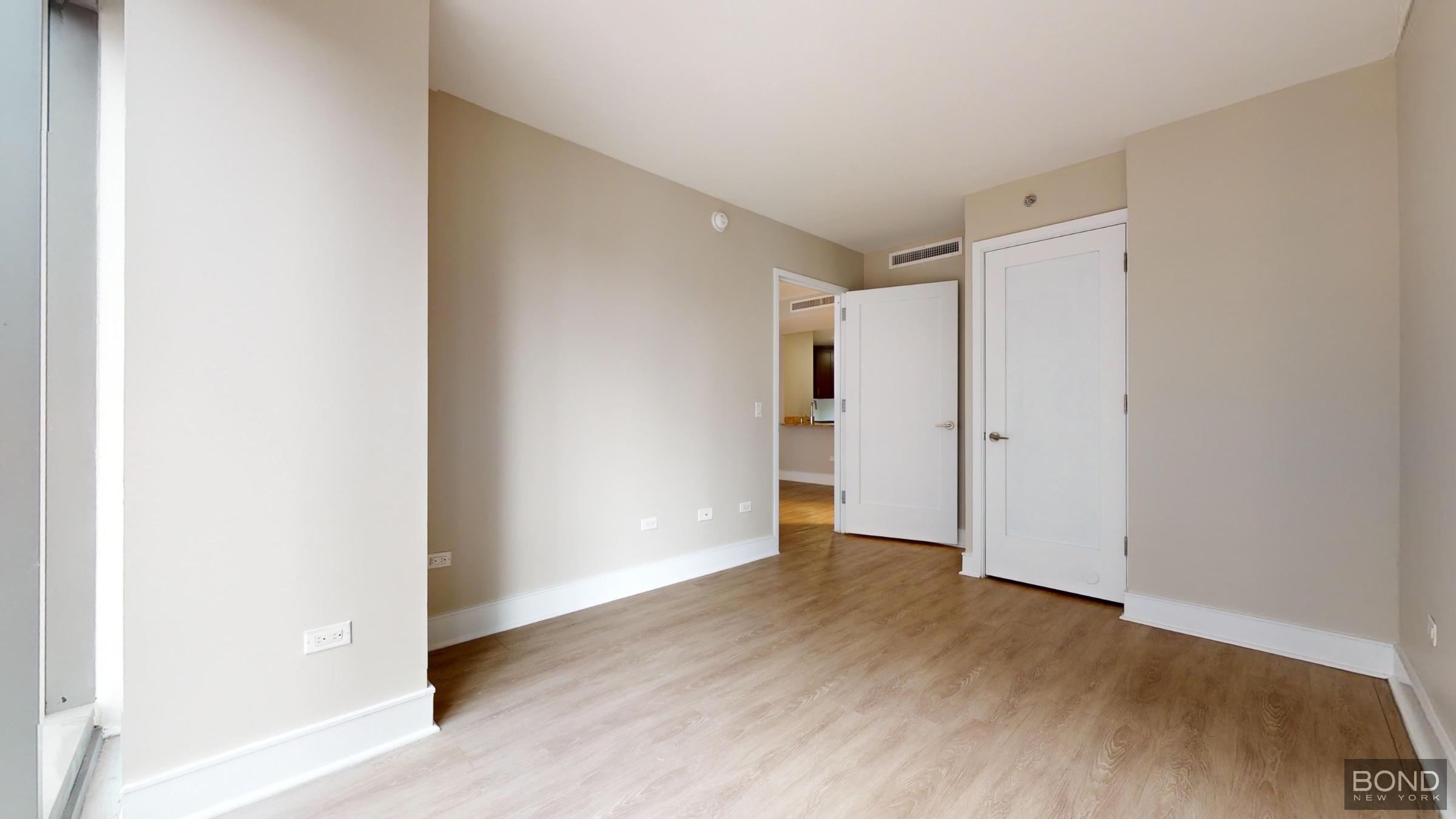 237 East 34th Street, Unit 1503 Manhattan, NY 10016 - Photo 14 of 24 a view of an empty room with wooden floor