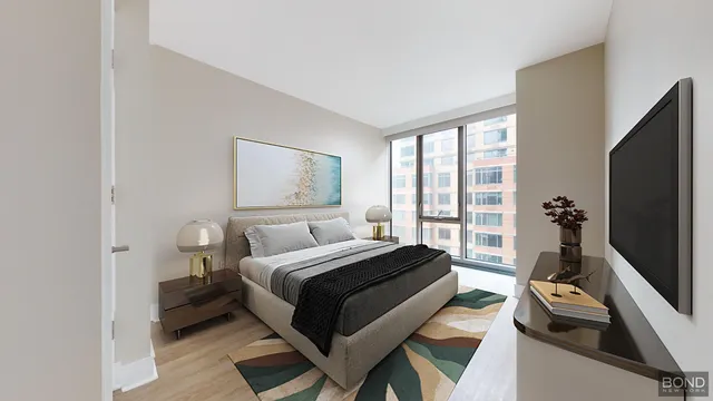 a bedroom with a bed and a flat tv screen next to a window