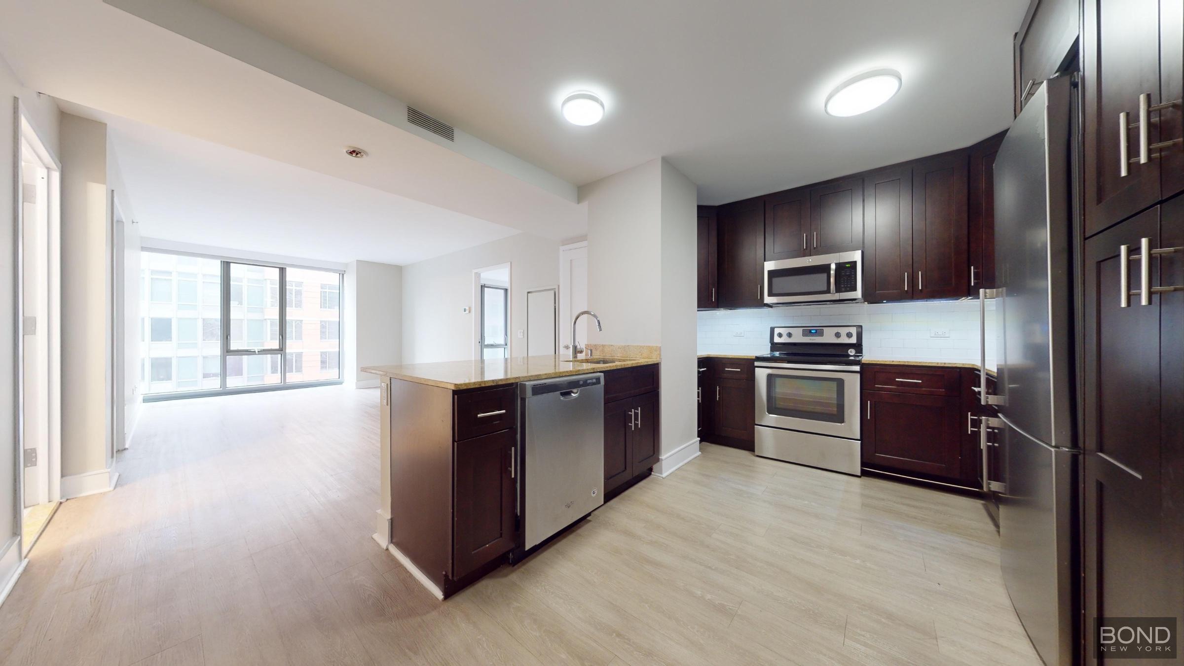 237 East 34th Street, Unit 1503 Manhattan, NY 10016 - Photo 5 of 24 a kitchen with stainless steel appliances kitchen island granite countertop a refrigerator stove and oven