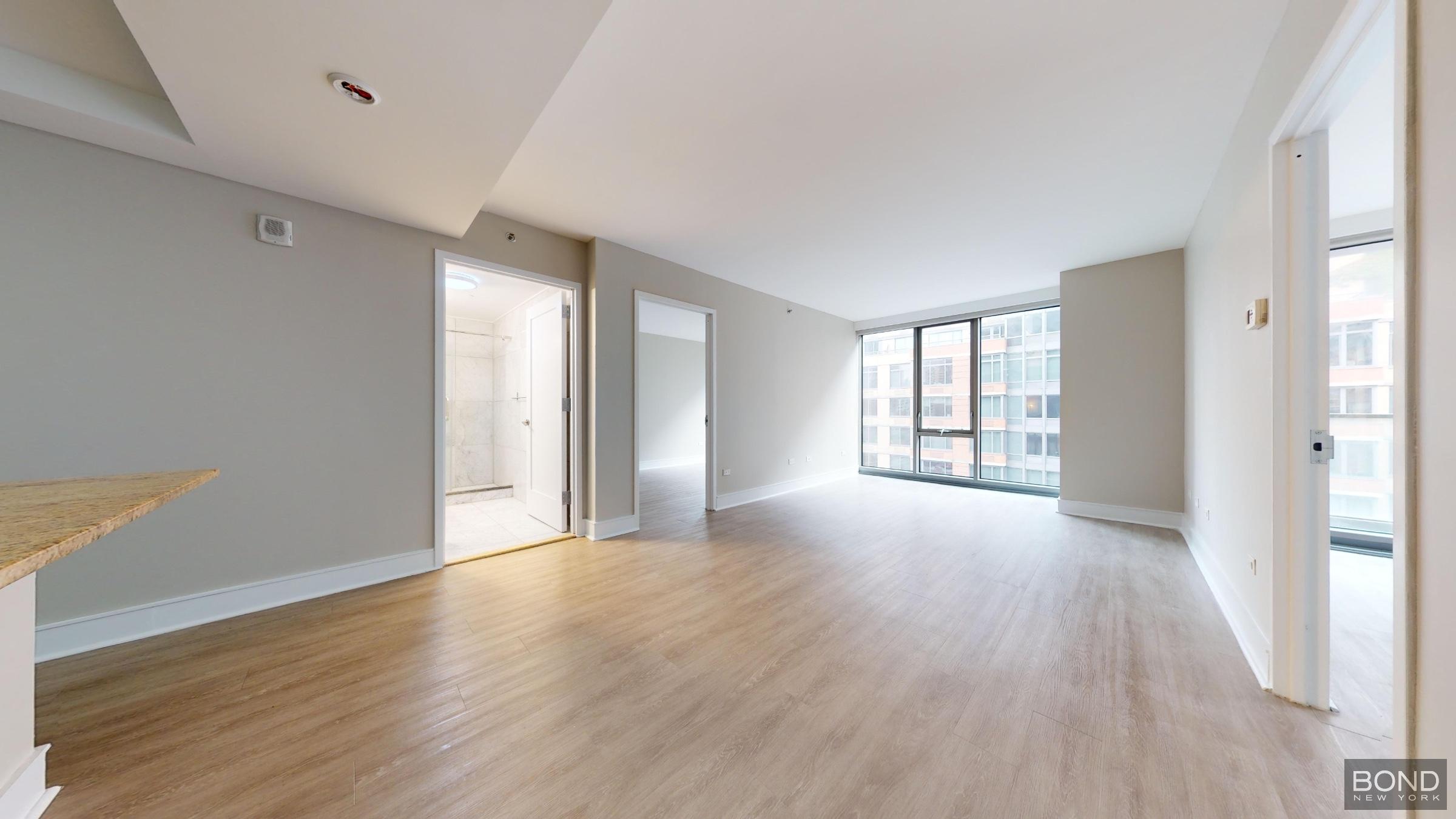 237 East 34th Street, Unit 1503 Manhattan, NY 10016 - Photo 7 of 24 a view of an empty room with window and wooden floor