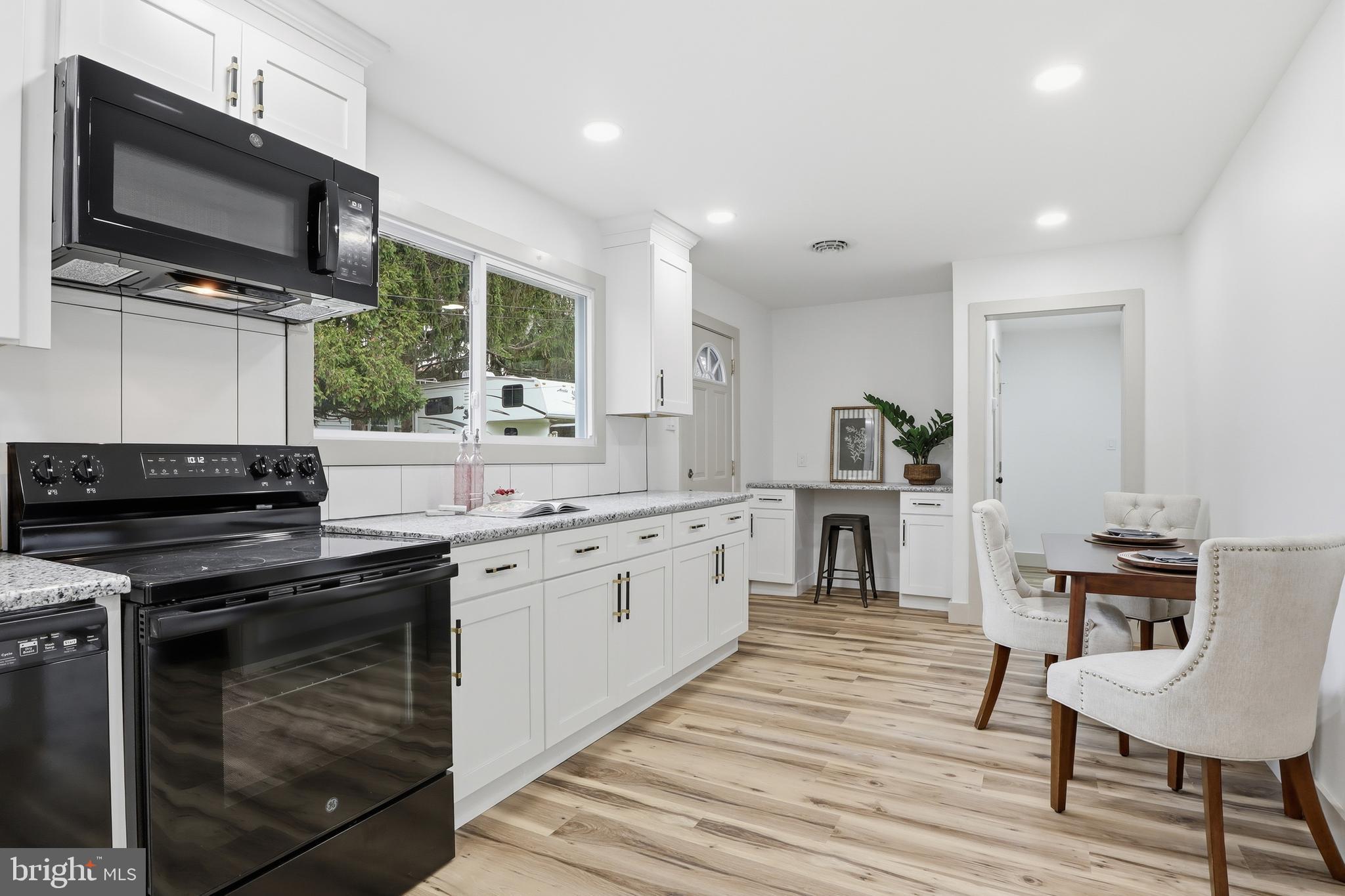 1512 Continental Road York, PA 17404 - Photo 7 of 23 a kitchen with stainless steel appliances granite countertop a stove top oven a sink dishwasher a dining table and chairs with wooden floor