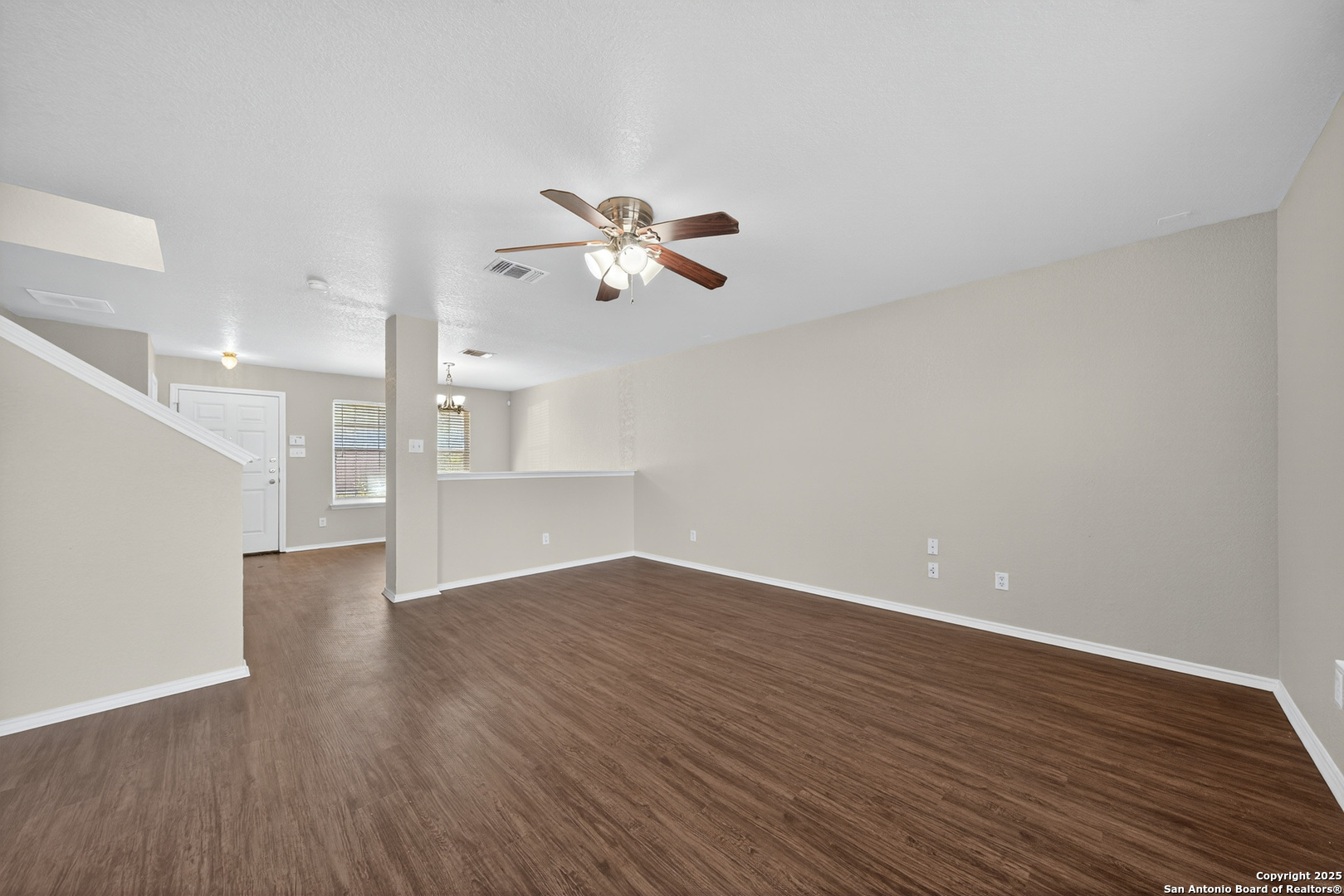 9619 Copper Spring Converse, TX 78109 - Photo 11 of 31 an empty room with wooden floor chandelier fan and windows