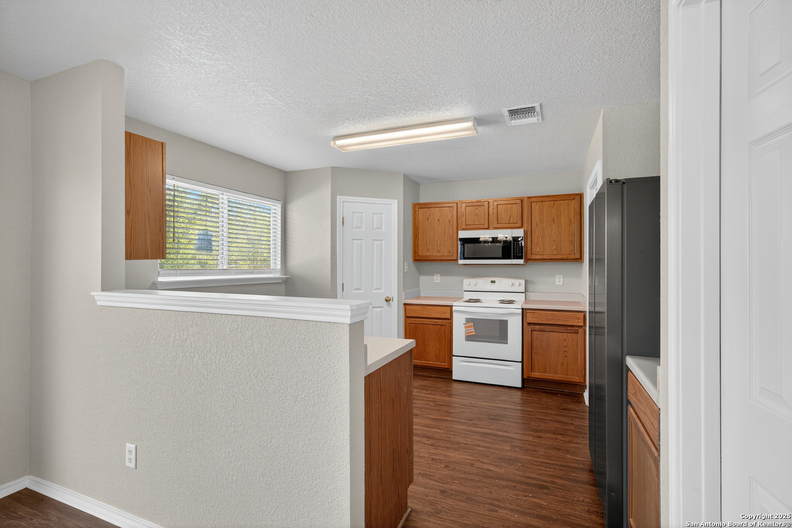 9619 Copper Spring Converse, TX 78109 - Photo 13 of 31 a kitchen with stainless steel appliances granite countertop a stove and a refrigerator
