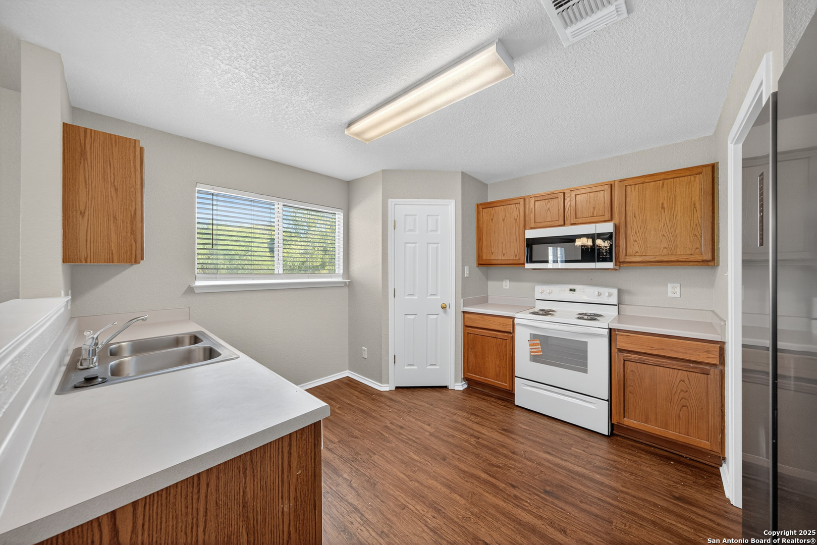 9619 Copper Spring Converse, TX 78109 - Photo 14 of 31 a kitchen with stainless steel appliances white stove a sink dishwasher and a refrigerator