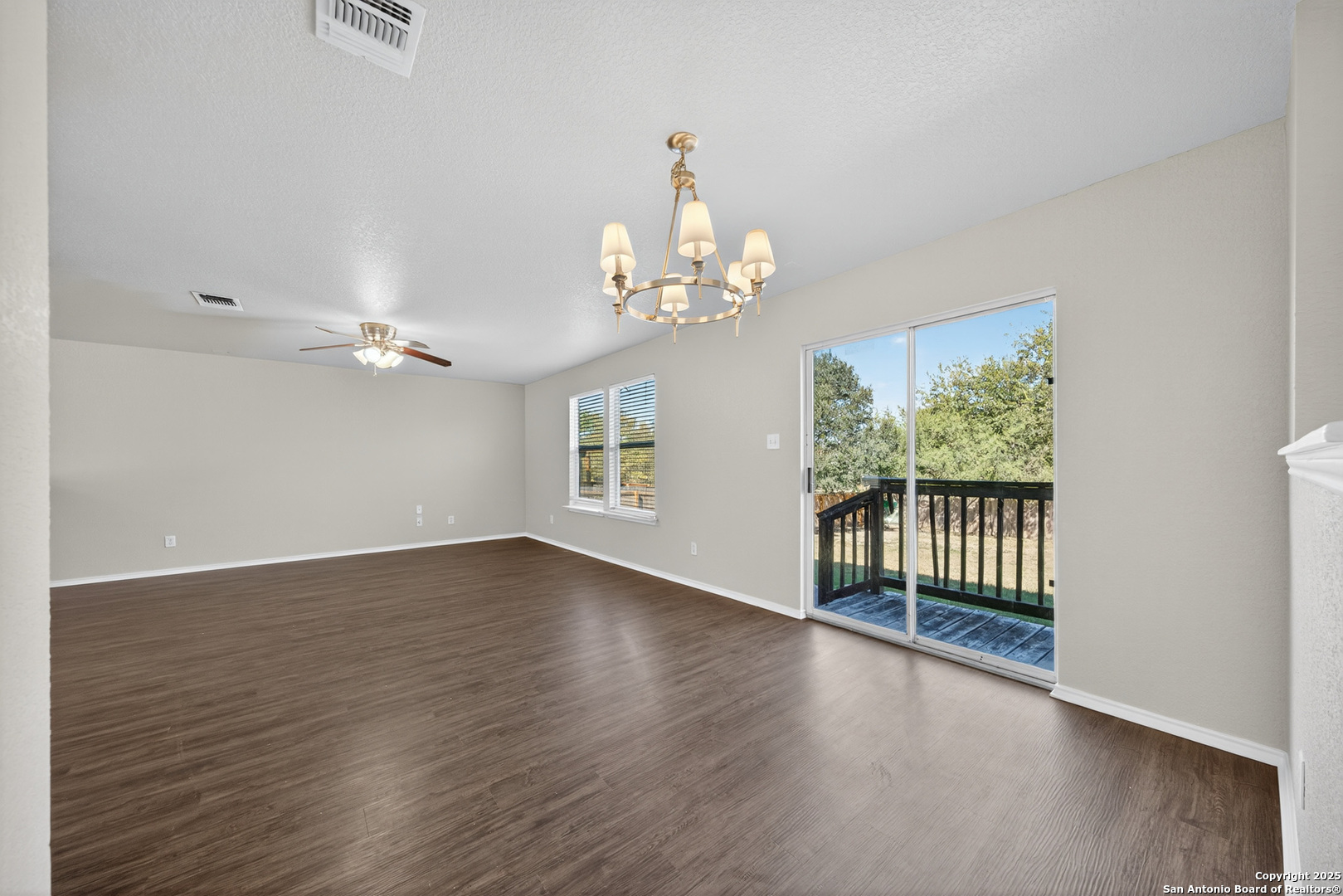 9619 Copper Spring Converse, TX 78109 - Photo 16 of 31 an empty room with wooden floor chandelier and windows