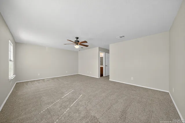 a view of an empty room with a ceiling fan
