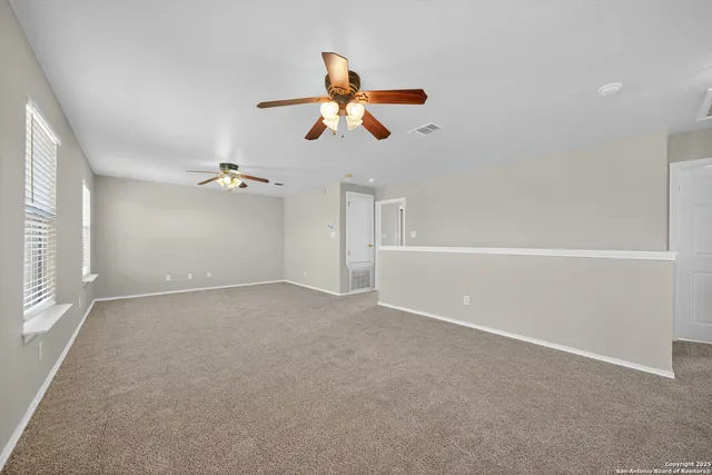 a view of empty room with a ceiling fan and window