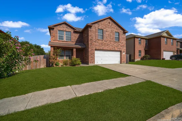 a front view of a house with a garden and yard