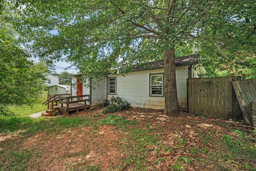 208 Holleman Street Seneca, SC 29678 - Photo 24 of 27 This charming home features a lovely outdoor space with mature trees and a private wooden fence.