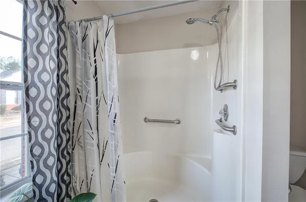 a bathroom with a shower curtain and a shower