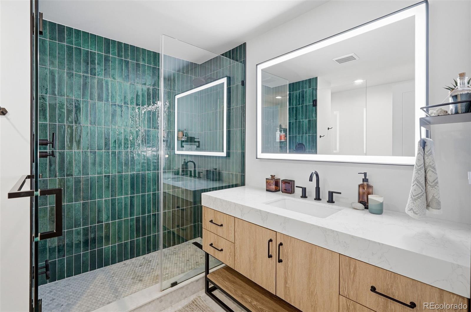 6940 Independence Street Arvada, CO 80004 - Photo 16 of 32 a bathroom with a sink mirror and shower