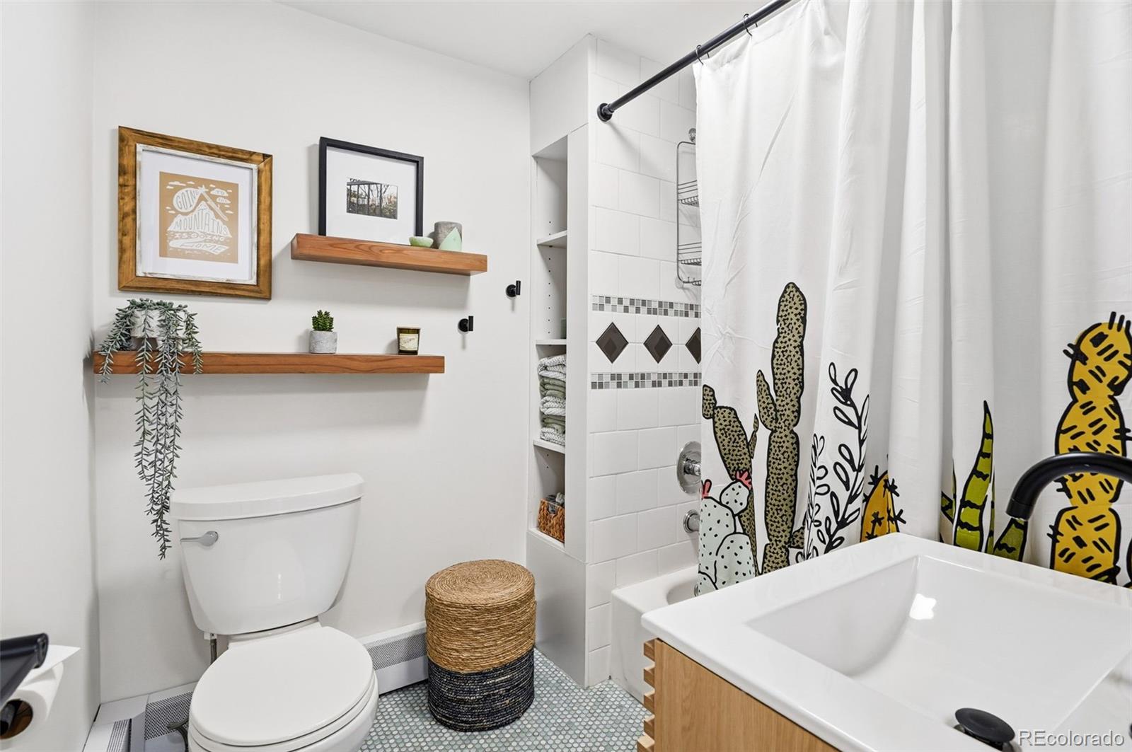 6940 Independence Street Arvada, CO 80004 - Photo 19 of 32 a bathroom with a sink a toilet and a mirror