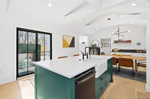 a kitchen with stainless steel appliances granite countertop a sink a stove a refrigerator cabinets and dining table