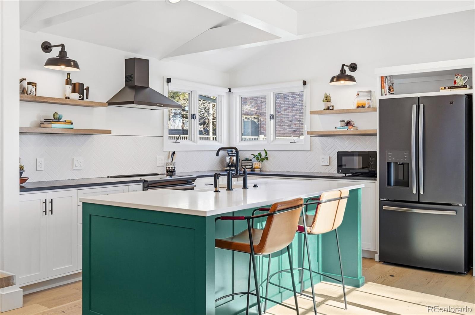6940 Independence Street Arvada, CO 80004 - Photo 9 of 32 a kitchen with stainless steel appliances granite countertop a sink and a refrigerator
