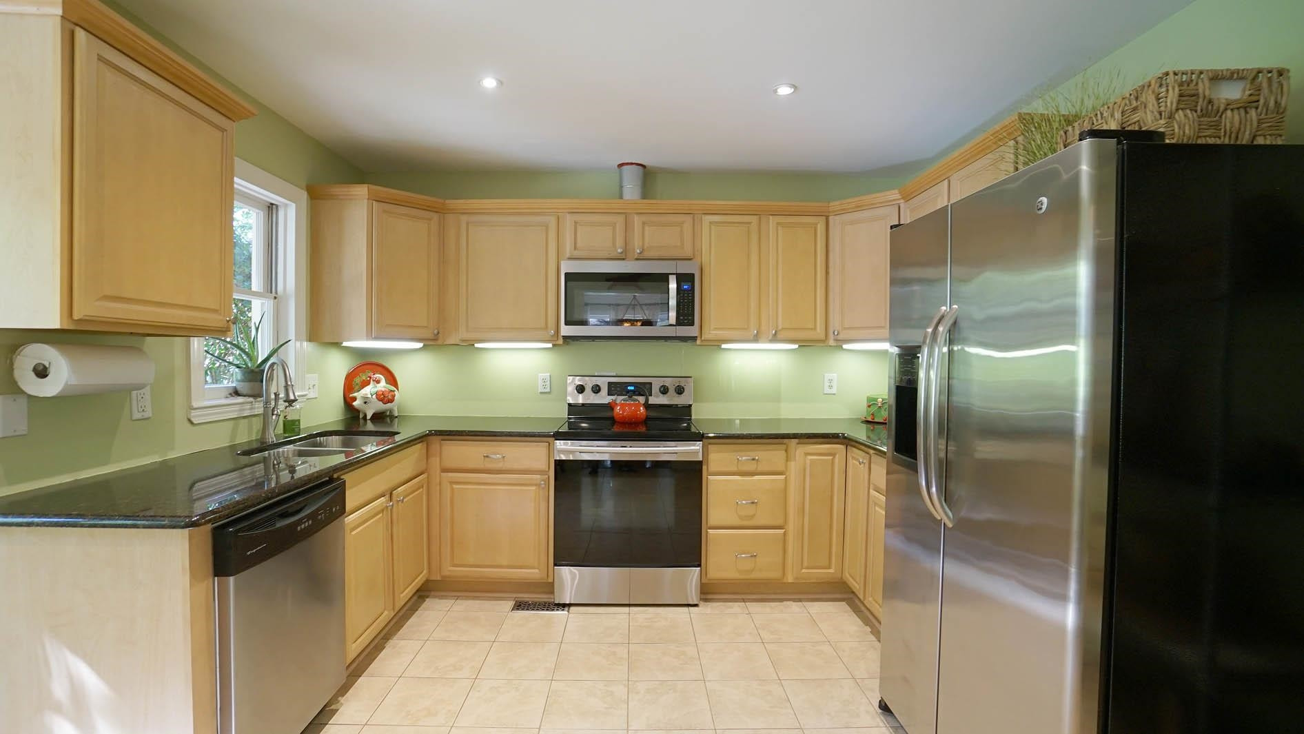 1809 Falls Church Road Raleigh, NC 27609 - Photo 3 of 56 a kitchen with a sink a microwave a refrigerator and cabinets