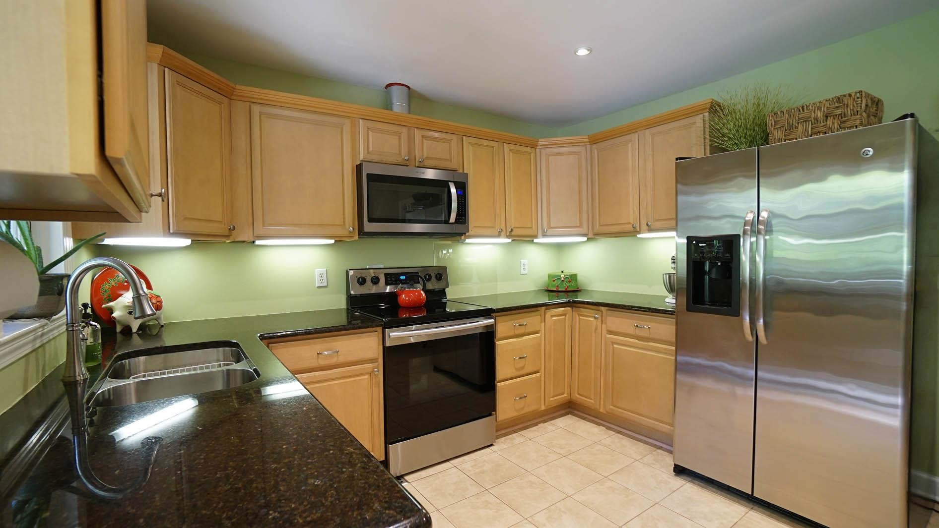 1809 Falls Church Road Raleigh, NC 27609 - Photo 5 of 56 a kitchen with granite countertop a refrigerator and a stove top oven