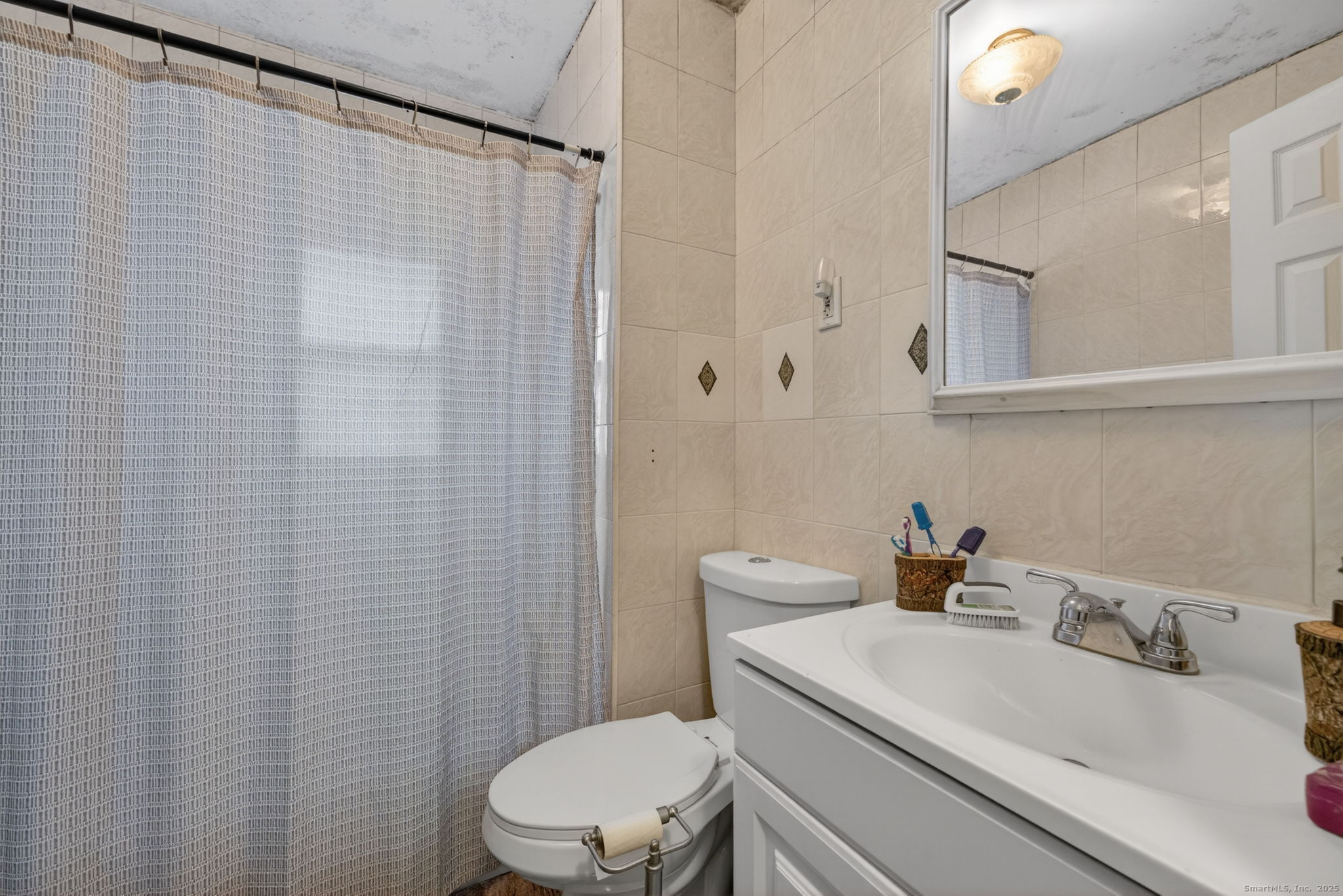 38 Center Street Bristol, CT 06010 - Photo 25 of 28 a bathroom with a sink a toilet and a mirror