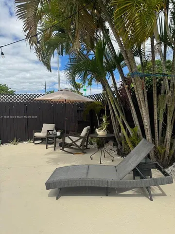 a view of swimming pool with outdoor seating and trees in the background