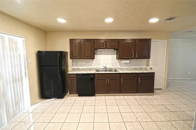a kitchen with a sink a refrigerator and cabinets