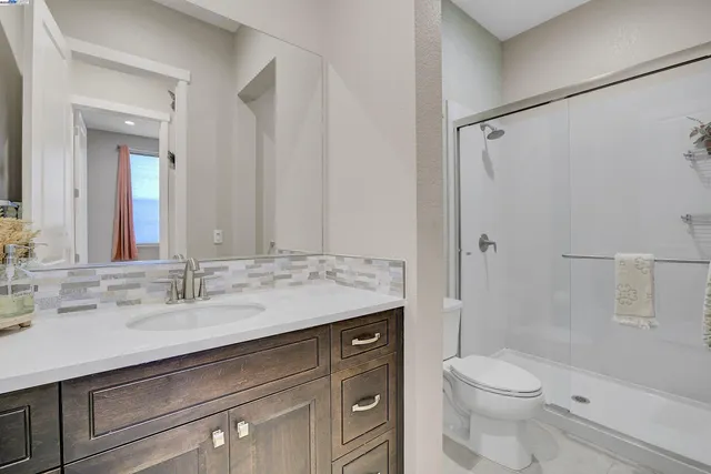 a bathroom with a granite countertop sink toilet and shower
